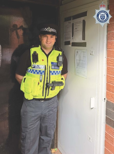 A police officer outside the property which has been closed 